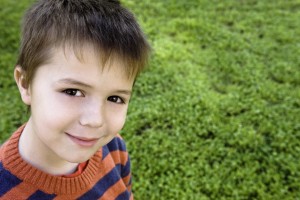 close up of young caucasian boy in grass